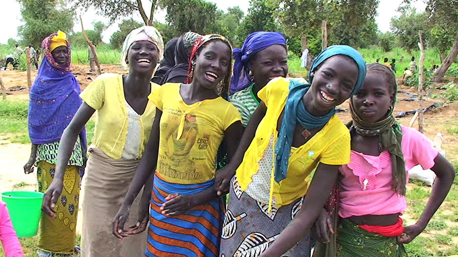 girls clowning by the village water well