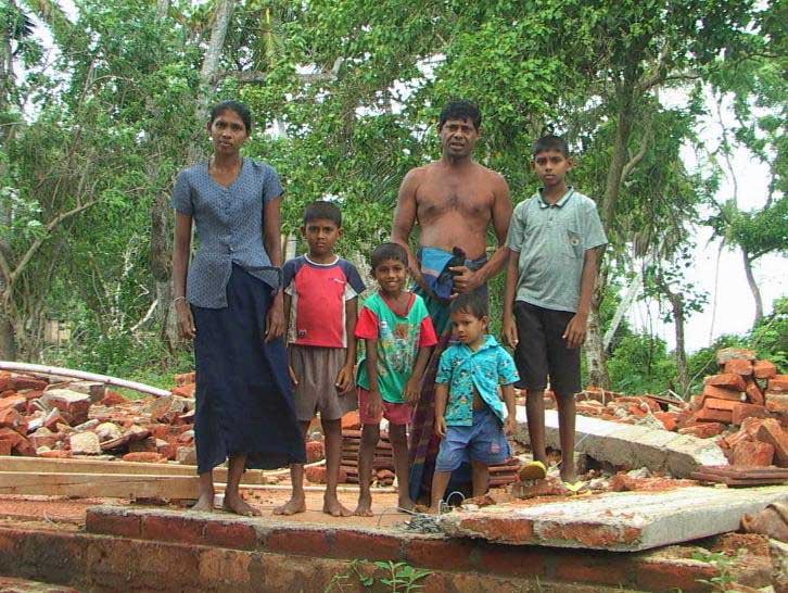 Jayasiri and his family atop house ruins in Sri Lanka