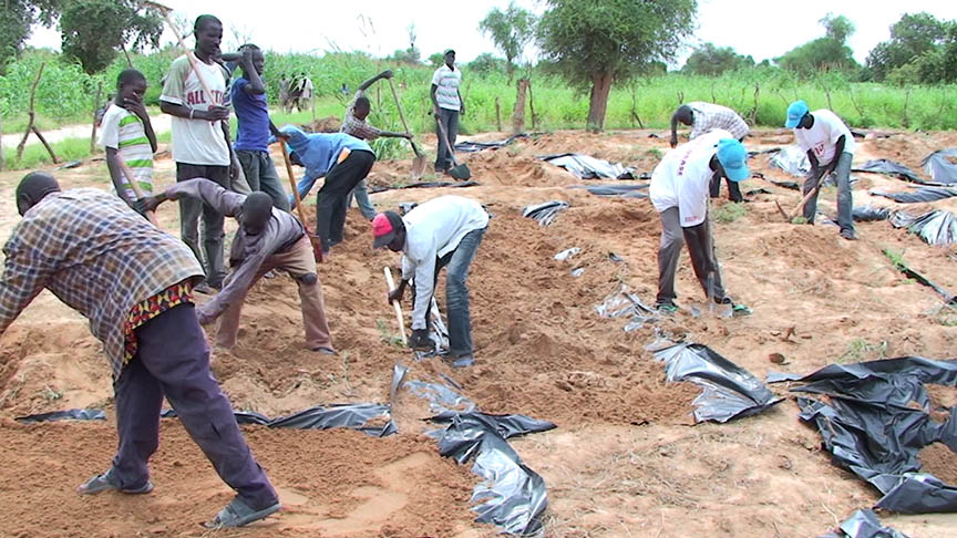 Men of Handaga Village working in the community garden